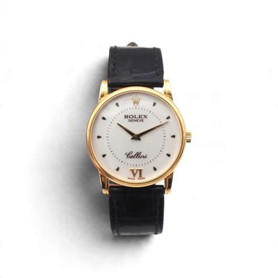 gros plan d'une montre sur une surface blanche avec un bracelet noir