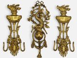 three antique brass wall sconces on a white background