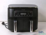 a black air fryer sitting on a counter top