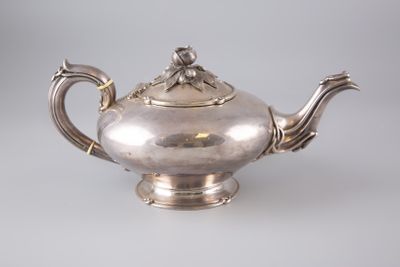 une théière ancienne en argent, munie d'une anse et d'un couvercle