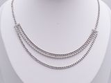 silver chain necklace on a mannequin display on a white surface