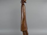 a wooden statue of a man with a hat and coat