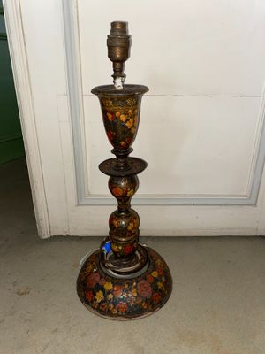 a metal candle holder that has a flower design on it