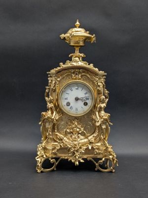 a gold clock sitting on top of a black table