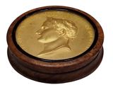 a gold coin in a wooden box on a white background