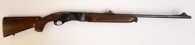 un fusil accroché au mur d'une pièce aux murs blancs