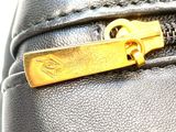 a close up of a black purse with a gold zipper