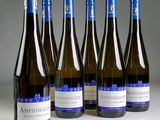 six bouteilles de vin sont alignées sur une table
