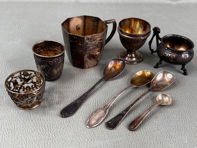 a lot of silver spoons and cups on the table