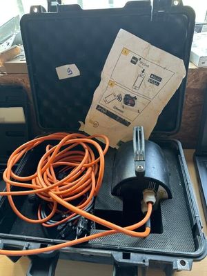 une mallette noire contenant un tuyau orange, posée sur une table