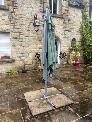 un parapluie posé sur un support à l'extérieur d'une maison