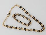 a close up of a necklace and bracelet on a white surface