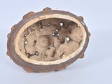 a brown vase with holes in it sitting on a white surface