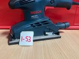 une ponceuse orbitale Bosch posée sur une table, avec son étiquette de prix