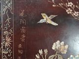 a brown table with a bird and flowers on it