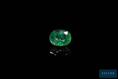 a green emerald stone on a black surface