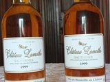 deux bouteilles de vin posées sur une table devant une porte en bois