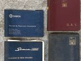 Plusieurs livres sont alignés sur une surface en béton ; parmi eux, l'un est rouge et l'autre bleu.