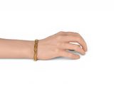 an image of a woman ' s hand with a gold bracelet
