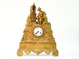 une horloge dorée posée sur une table blanche