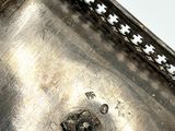 a silver plate with a cross pattern on it