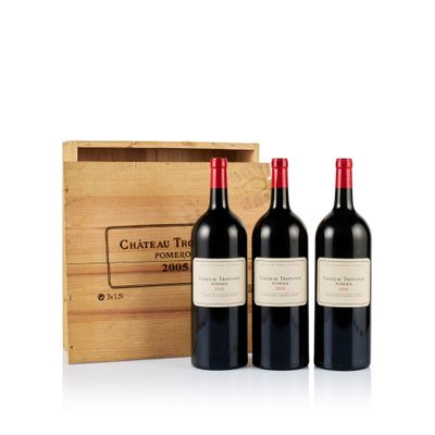three bottles of red wine in front of a wooden box