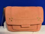 pink leather purse with gold hardware on top of a white counter