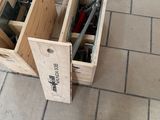 deux caisses en bois posées par terre, contenant des outils