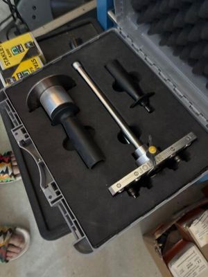 a tool in a case on the floor next to a pair of shoes