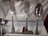 three forks and spoons in a box with silverware in it