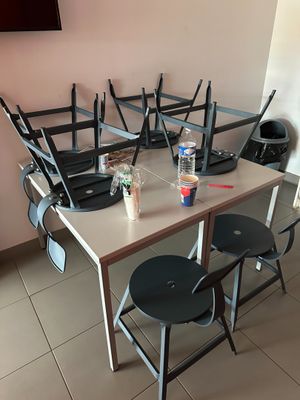 une table et des chaises dans une pièce où une télévision est accrochée au mur