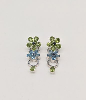 une paire de boucles d'oreilles ornées de fleurs vertes et bleues