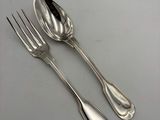 deux cuillères en argent et une fourchette posées sur une table
