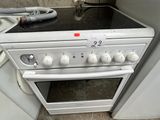 a white stove top oven sitting in a kitchen next to a washer and dryer