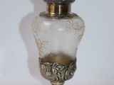 a small glass vase with a gold lid on a white table