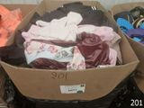 a cardboard box filled with clothes and other items