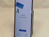 a close up of a cell phone on a table with a sign that says welcome