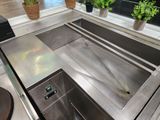 a stainless steel sink in the middle of a kitchen