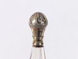 a glass bottle with a silver top on a table