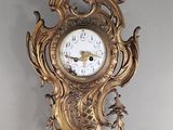 une horloge en or accrochée au mur de la pièce