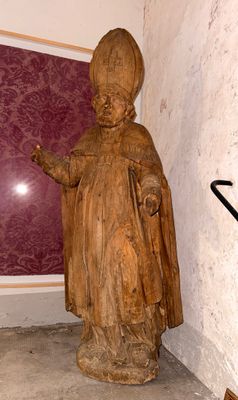 une statue représentant un homme tenant un parapluie dans un coin d'une pièce