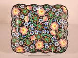a close up of a black plate with colorful flowers on it
