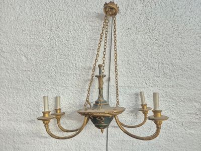 a chandelier hanging on the wall with three candles