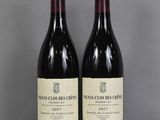 two bottles of wine sitting on top of a table next to each other