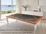 une photo d'un salon avec une grande table en verre
