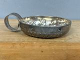 a metal bowl with a handle on a wooden table