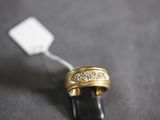 a gold ring with diamonds on it on a black surface