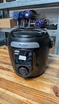a black and silver air fryer sitting on a wooden table