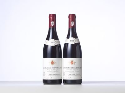 two bottles of red wine sitting on top of a table