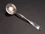a silver spoon with a spoon handle on a black surface